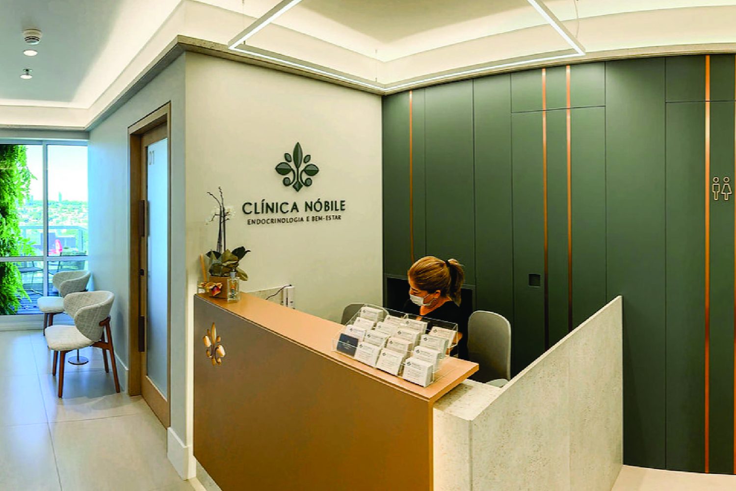 Recepção de clínica com o logotipo em acrílico aplicado na parede, executado pela Strategy Comunicação Visual